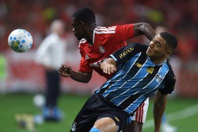 RS - FUTEBOL/BRASILEIRÃO/INTERNACIONAL X GRÊMIO - ESPORTES - Felix Torres, do Internacional, e   Carlos Vinicius, do Grêmio, disputam   bola durante partida válida pela décima   primeira rodada do Campeonato   Brasileiro, Série A, realizada no   estádio Beira-Rio, em Porto Alegre   (RS), na noite deste sábado, 11 de   abril de 2026.     11/04/2026 - Foto: EDU ANDRADE/FATOPRESS/ESTADÃO CONTEÚDO