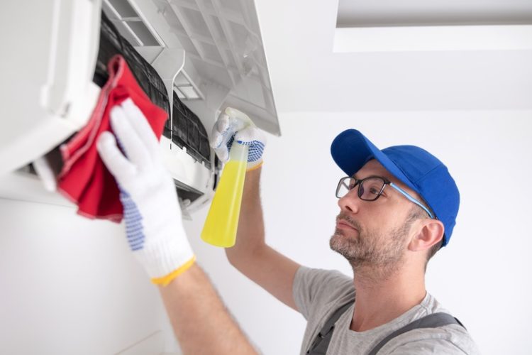 Service,Guy,Cleaning,And,Maintaining,Air,Condition,Unit.
