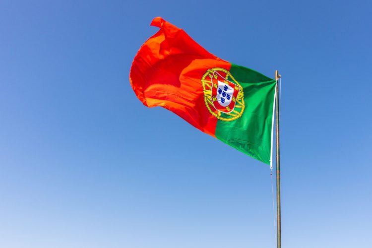 A beautiful shot of the Portuguese flag waving in the calm bright sky