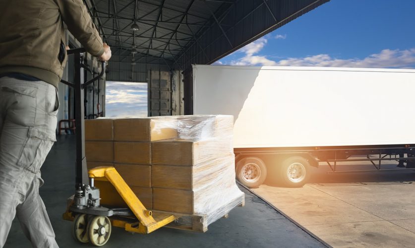 Worker courier unloading cargoshipment pallet goods, package box, his using hand pallet jack load into a truck, Road freight transport, Warehouse industrial delivery shipment and logistics
