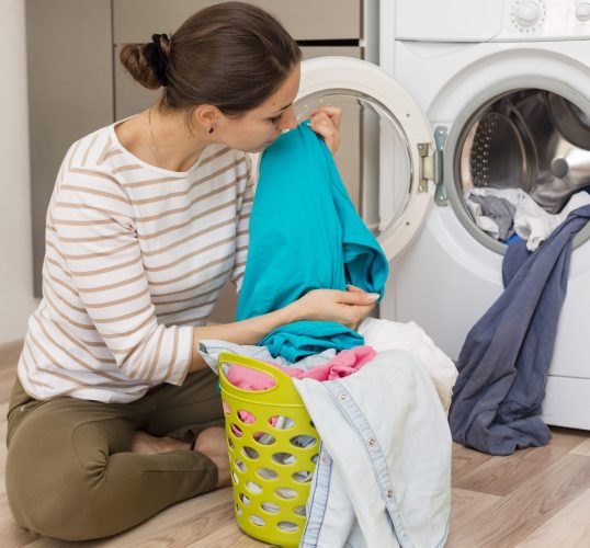 casual-woman-smelling-clean-laundry