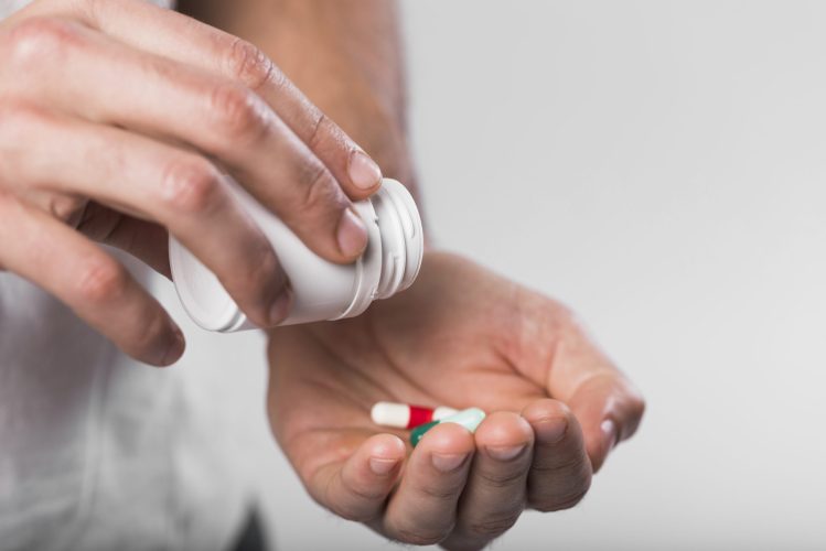 close-up-maos-segurando-capsulas-medicas