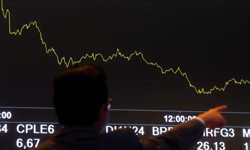 A man points front of an electronic board showing the graph of the recent fluctuations of market indices on the floor of Brazil's B3 Stock Exchange in Sao Paulo, Brazil October 19, 2021. REUTERS/Amanda Perobelli