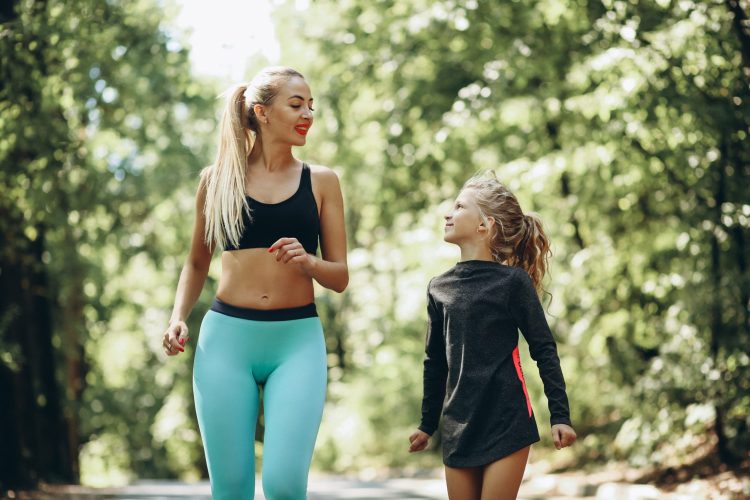 Woman with daughter jogging in park