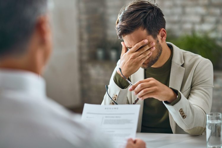Worried male candidate having a job interview with a manager in the office.