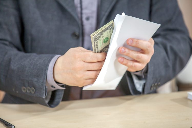A young businessman working from his office and counting cash money